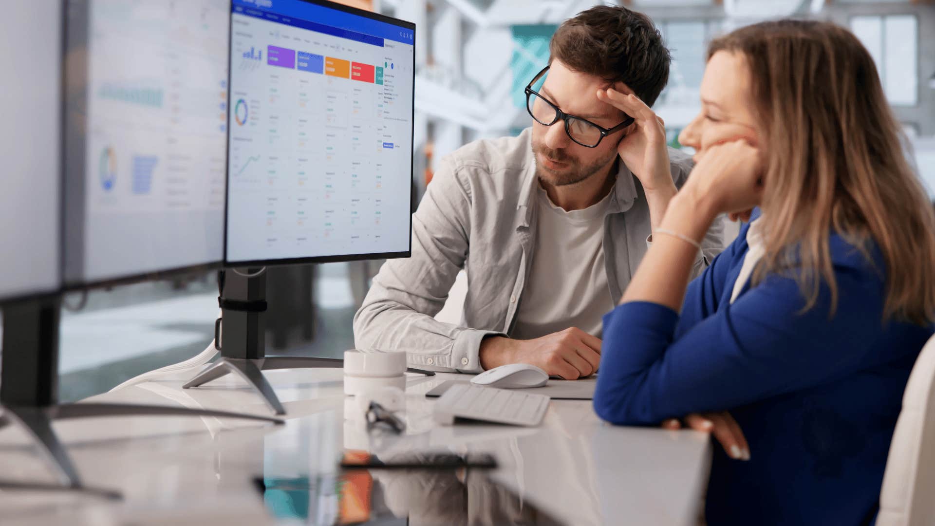 woman in blue shirt doing the bare minimum as she works with man