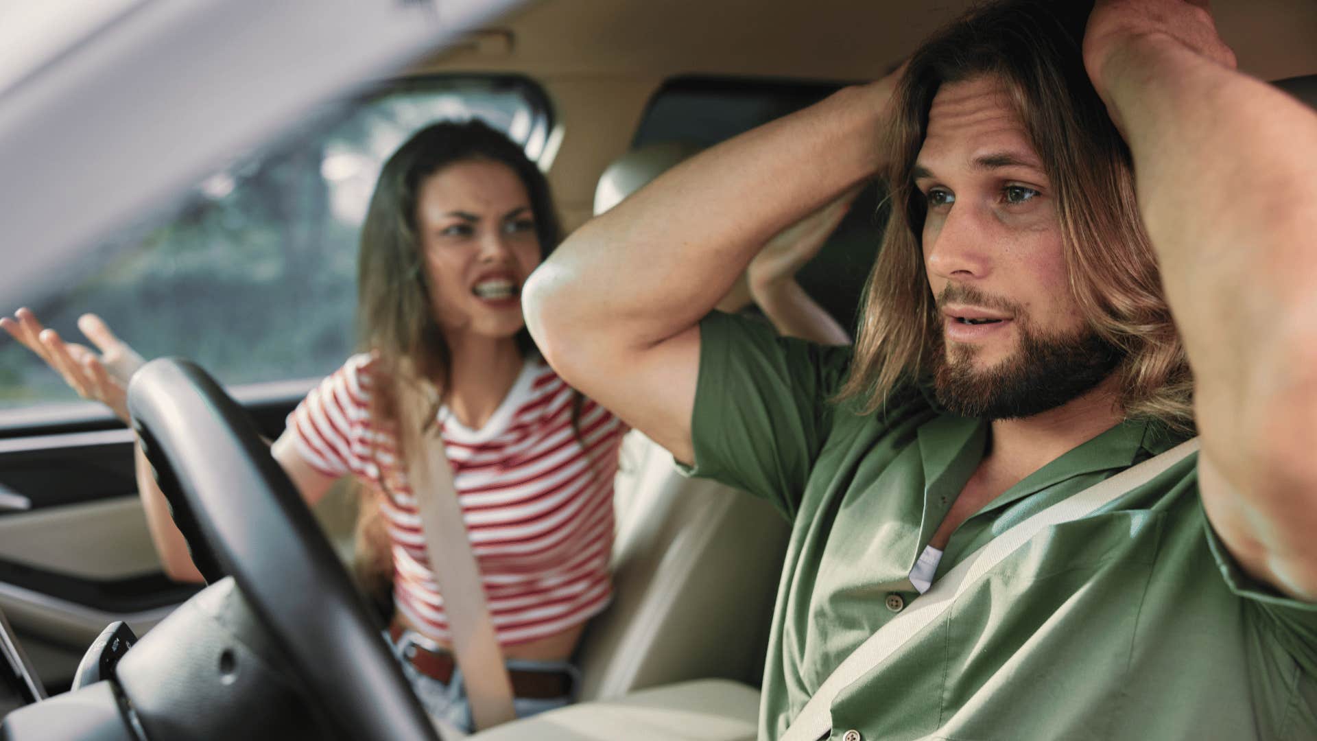 man in green shirt stressed as he's waiting to be told what to do by upset woman