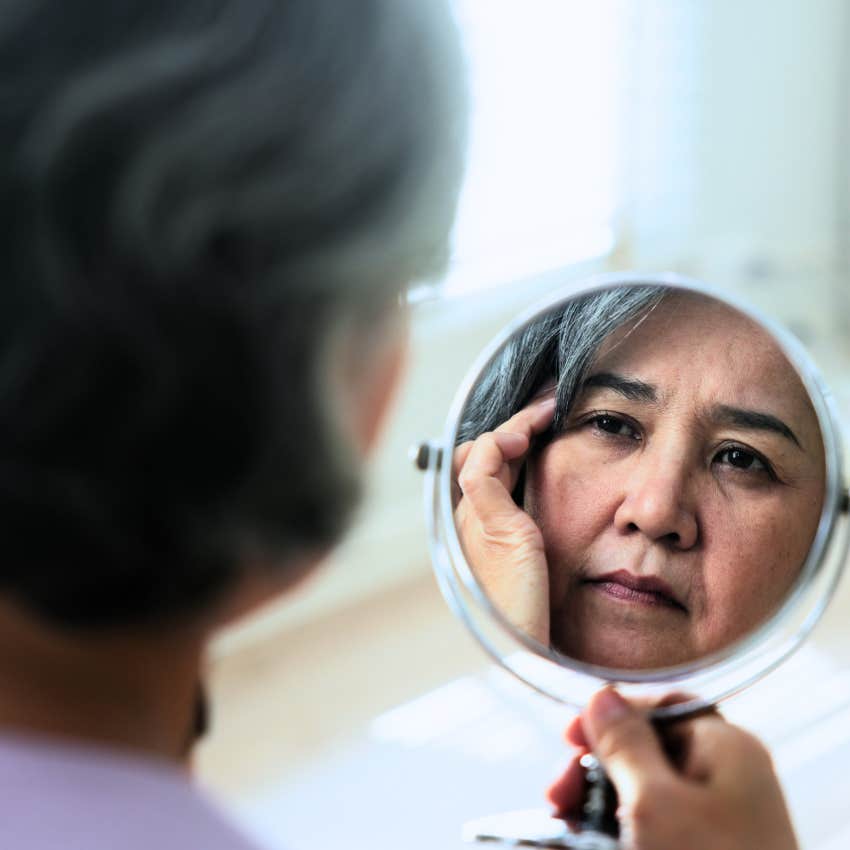 Woman trying to be perfect and looking in the mirror at home.