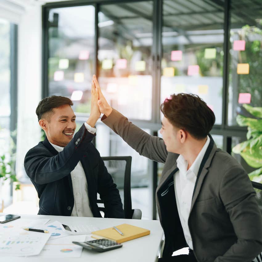 emotionally intelligent colleagues high-fiving not caring about the status of the other