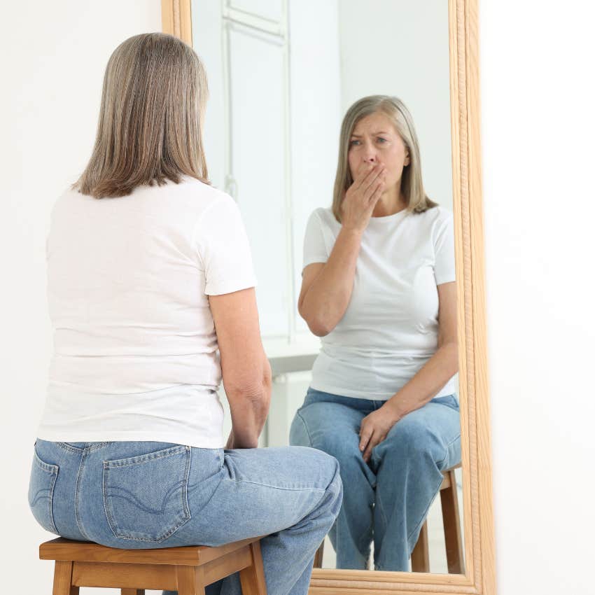 A woman who craves emotional freedom looks in the mirror sadly