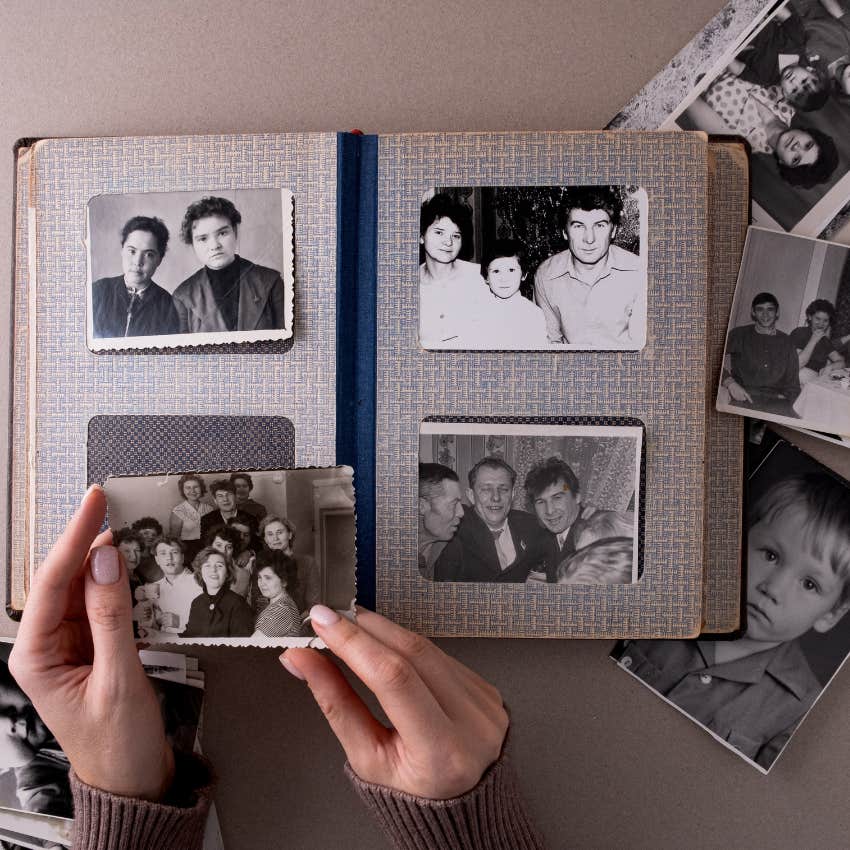 woman putting pictures from the 80s and 90s into her scrapbook