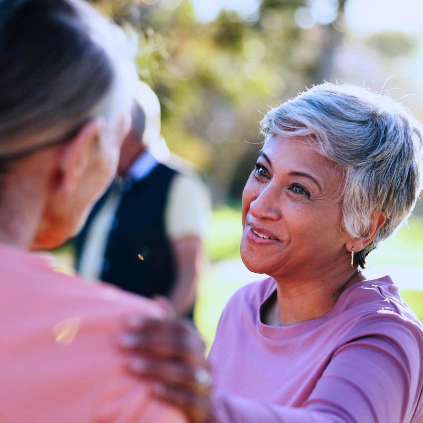 Woman who actively listens to everyone smiling at her friend.