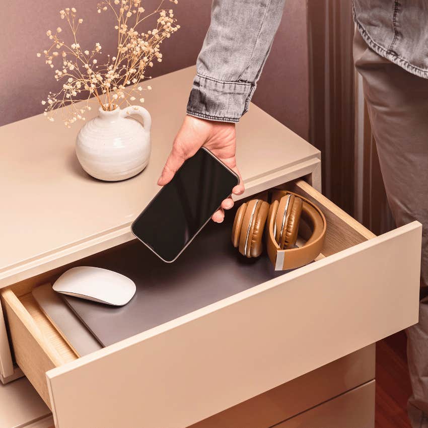 person who rarely gets distracted placing phone in drawer