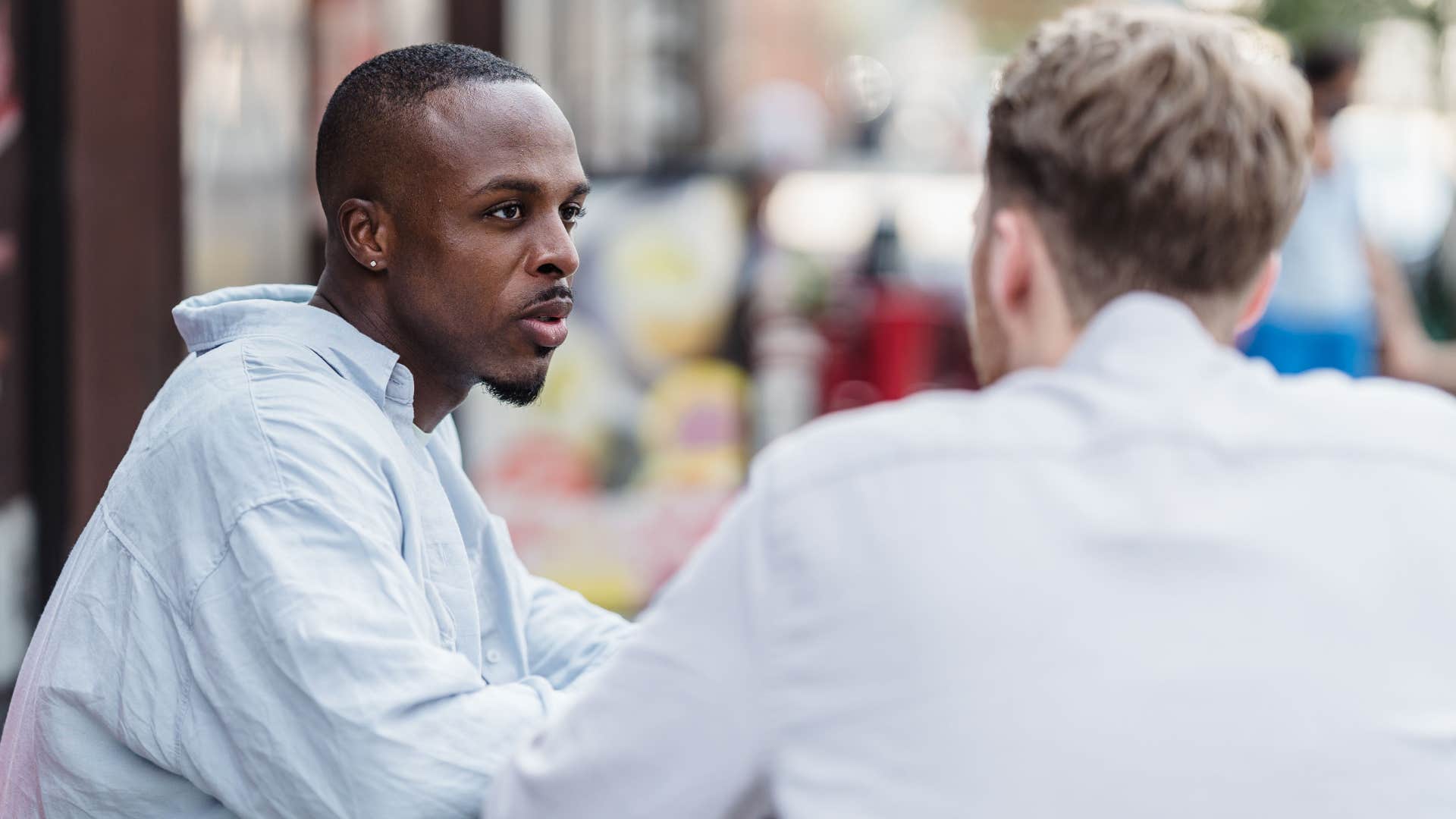 frustrated man talking to friend asking why are you doing this to me