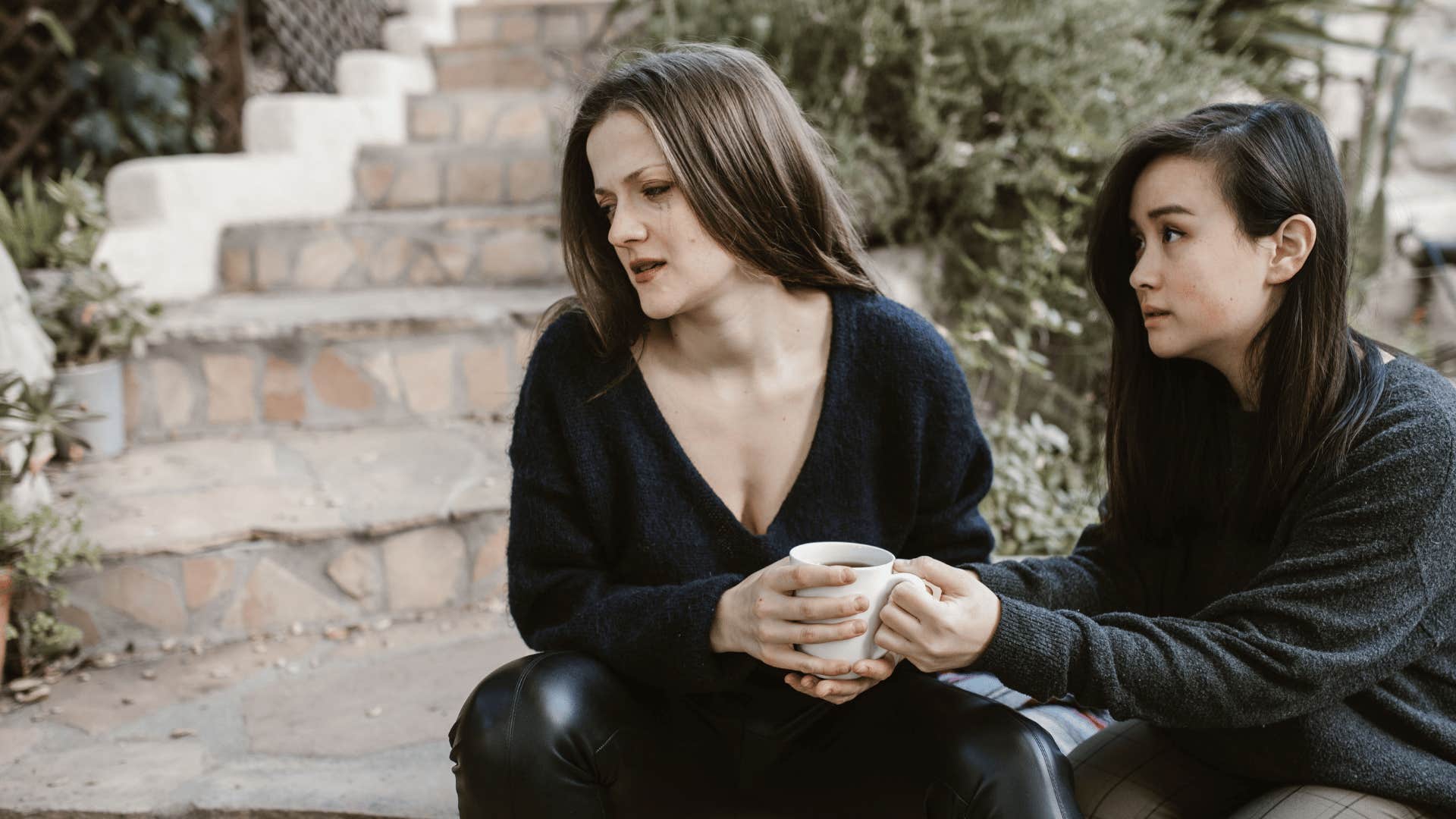 upset woman turned away from friend saying i don't want to talk about that