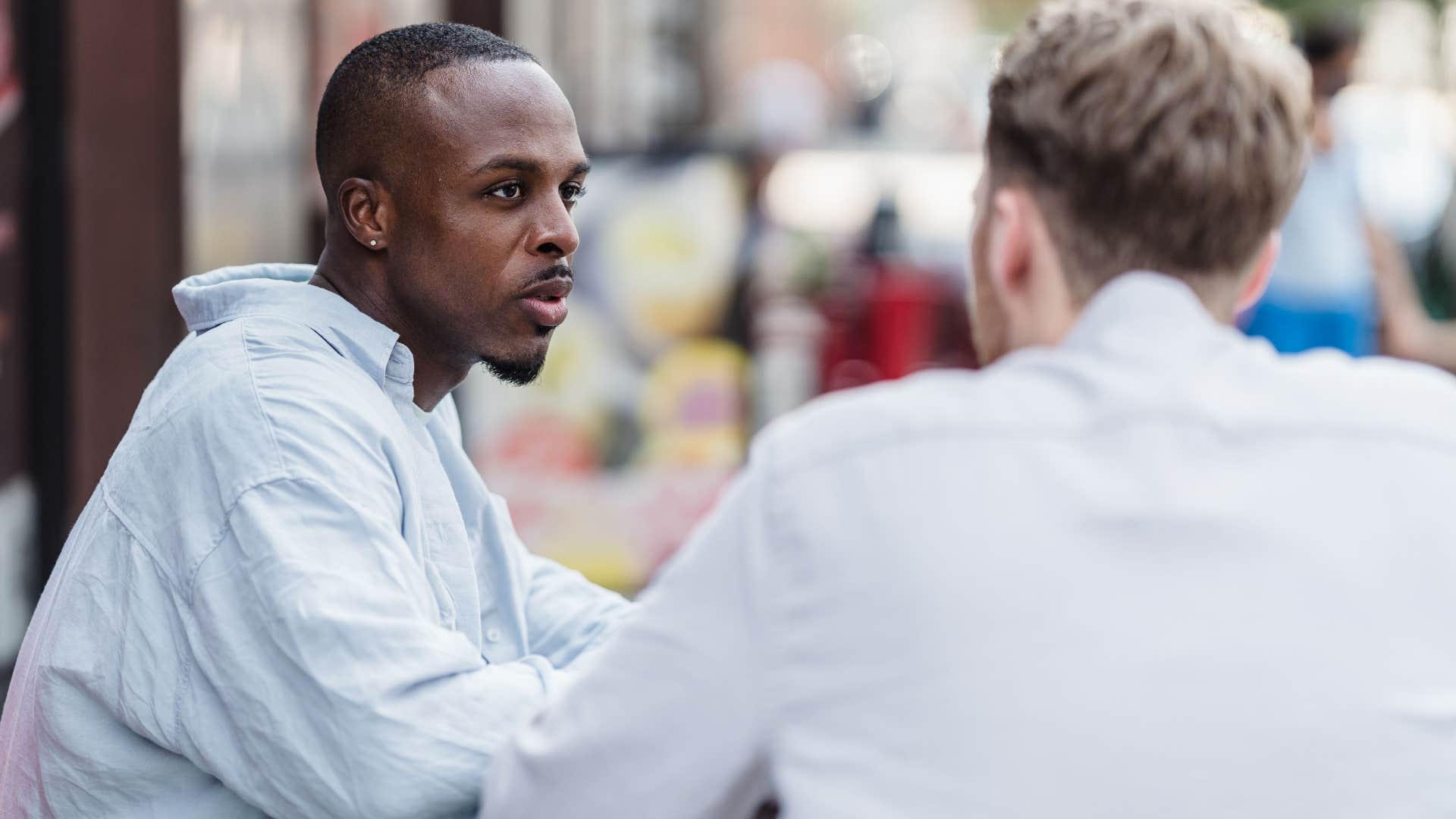 man feeling guilty during conversation with friend