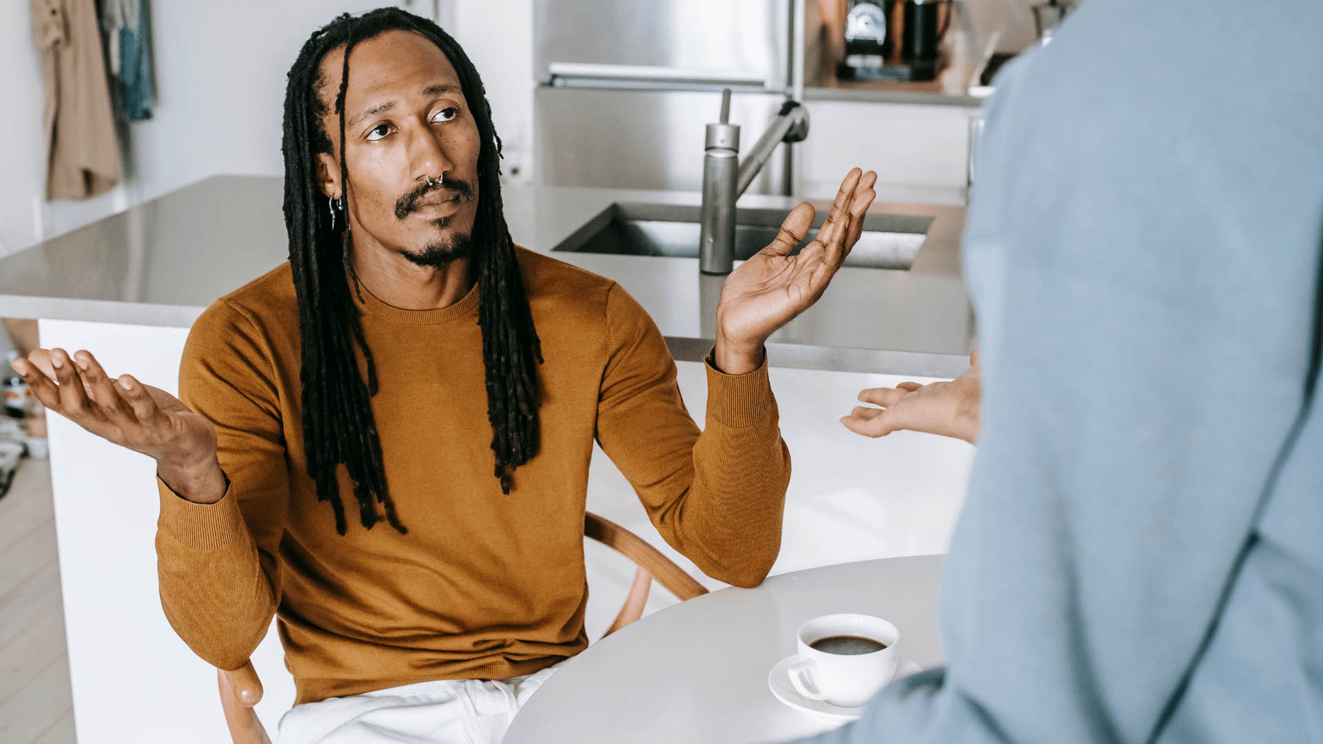 stoic intelligent man telling partner i'm getting ahead of myself shrugging