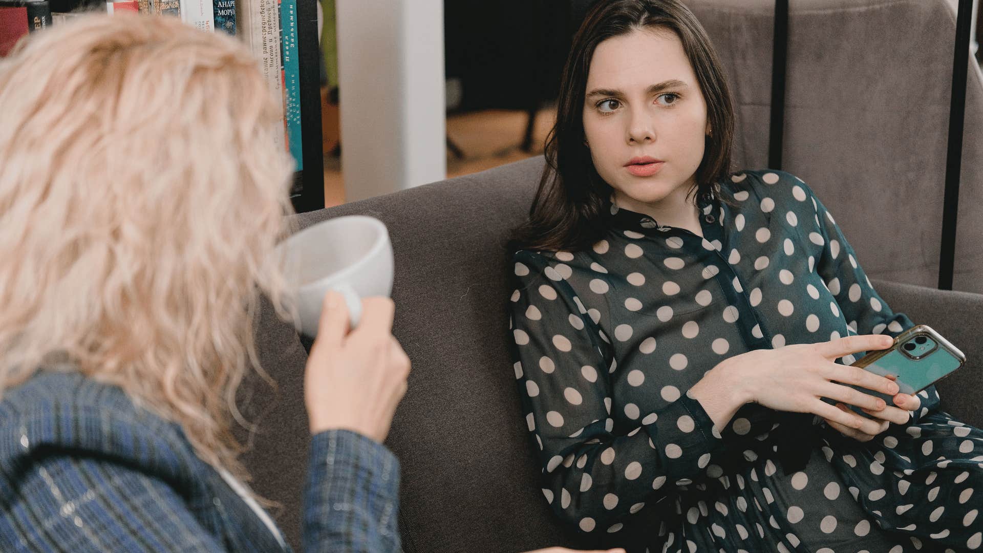 intelligent woman drinking coffee with friend apologizing for going off on a tangent