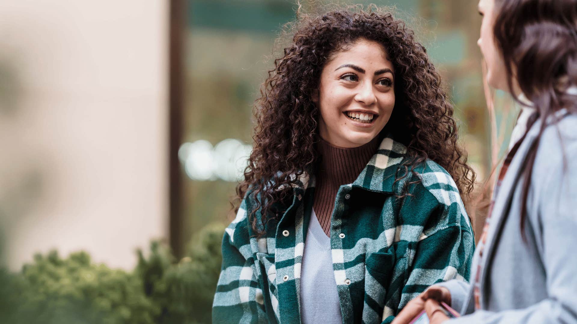 smiling intelligent woman talking to friend saying this reminds me of something
