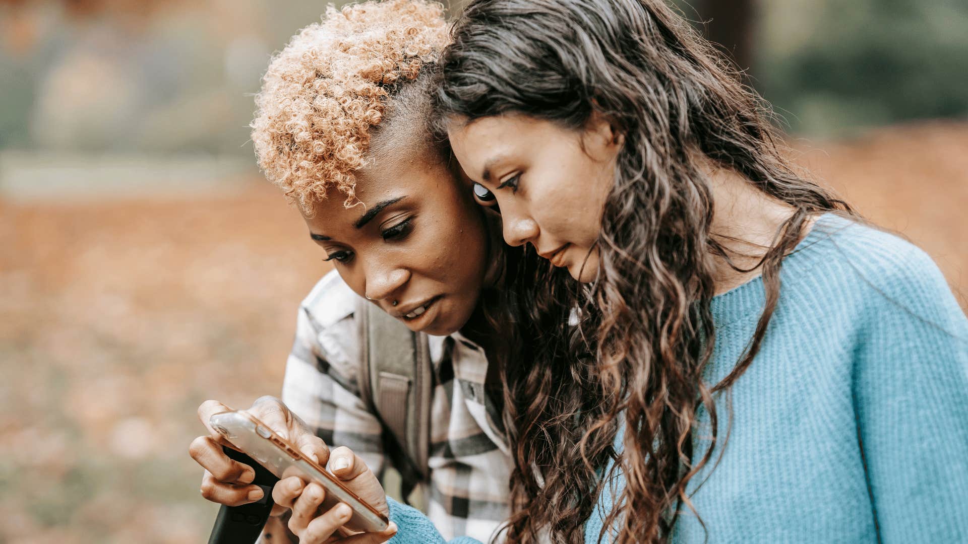 intelligent woman showing friend something on her phone