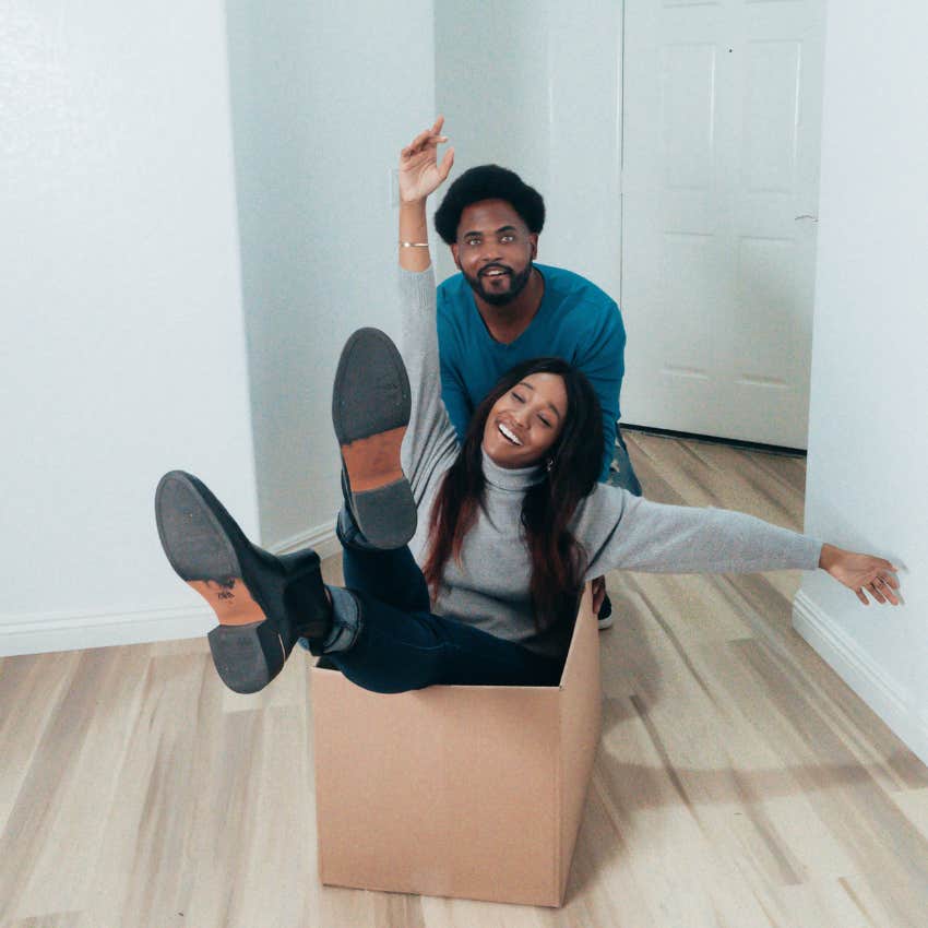 nerdy man pushing his partner in a box having fun