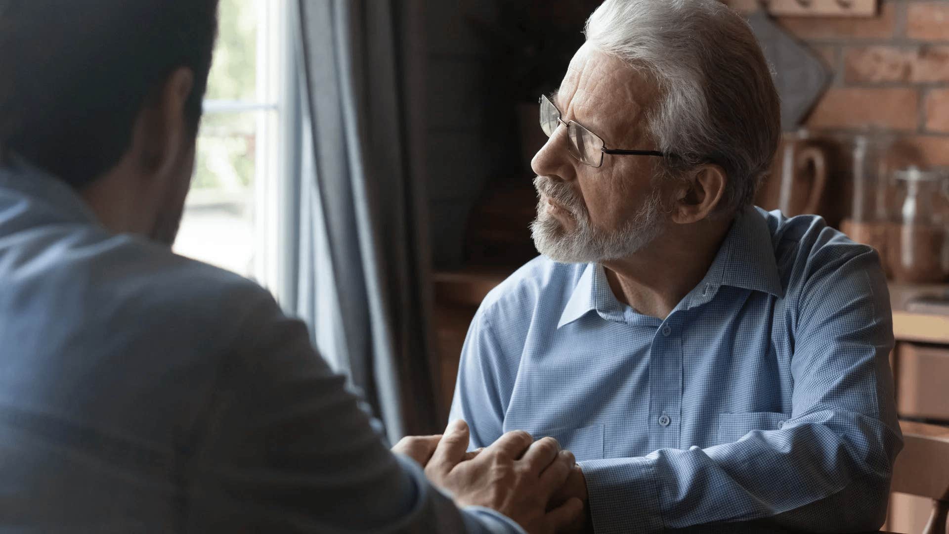 defiant older man talking to his controlling son