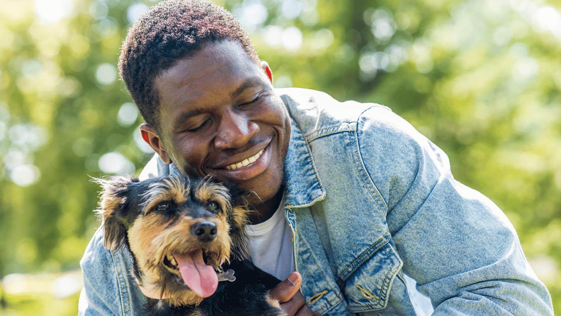man in jean jacket hugging dog as he says i'm more of an animal person
