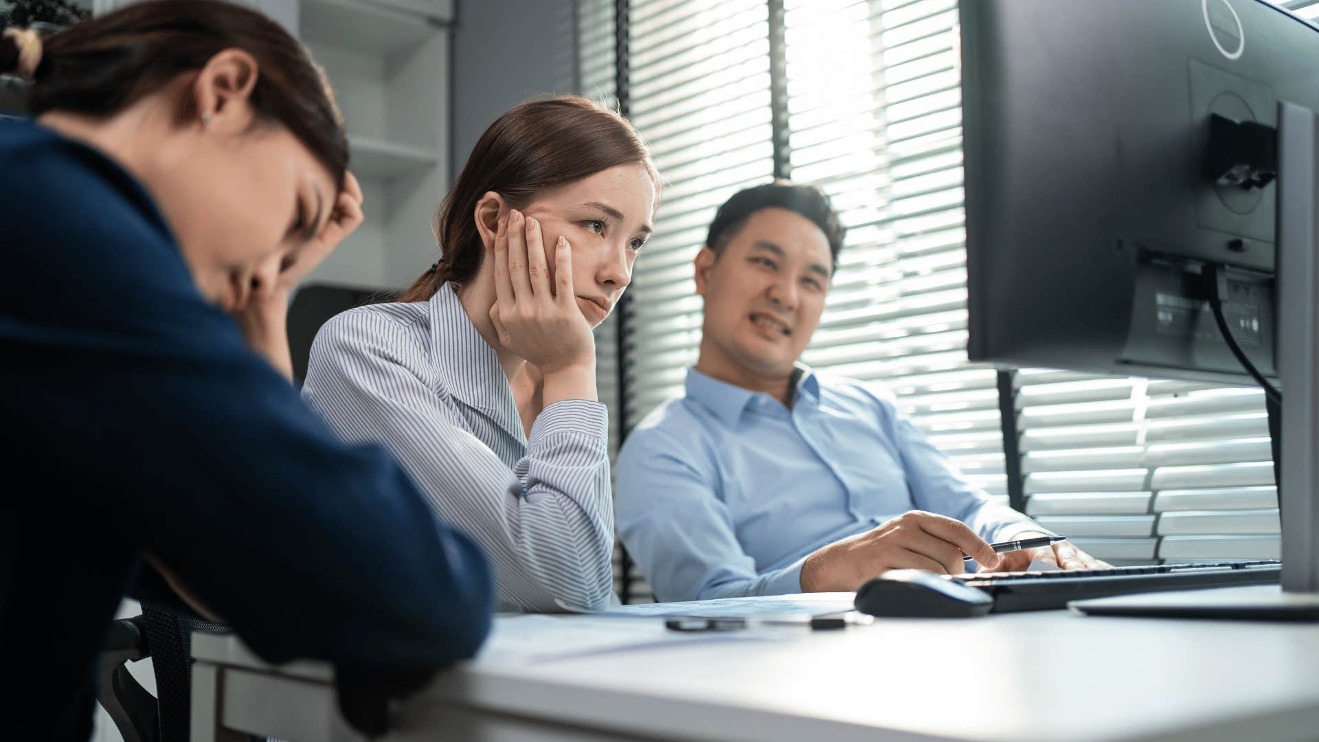 woman looking at computer annoyed as she thinks people are tiring