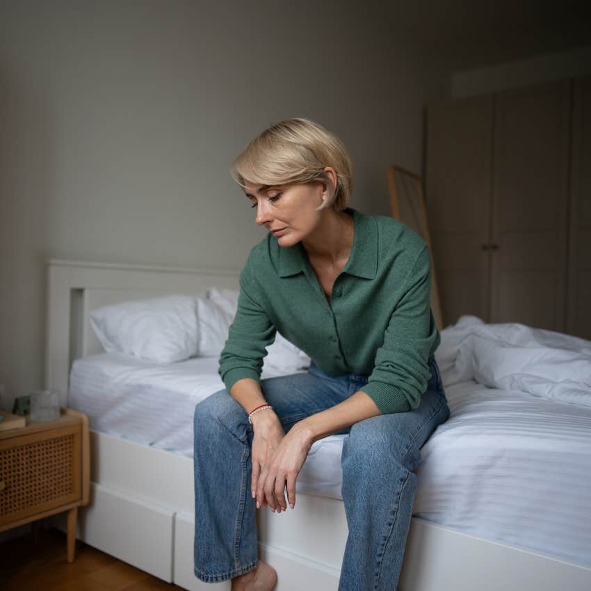 unmotivated woman sitting on an unmade bed saying I'll do it later