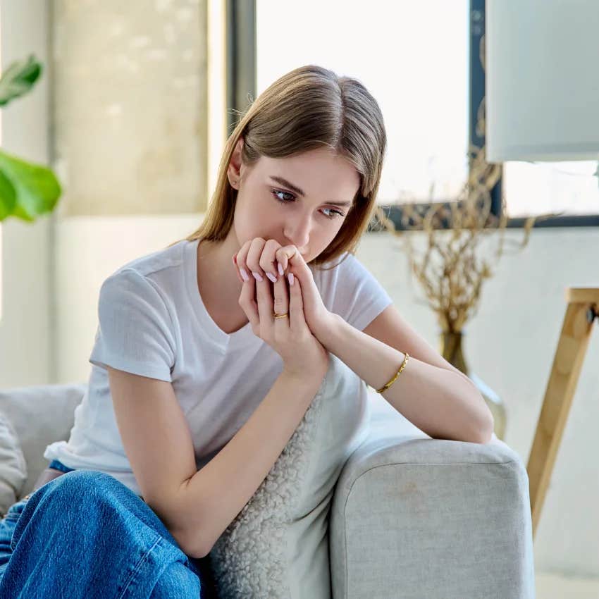 unmotivated woman sitting on the couch wondering what she should do with her life
