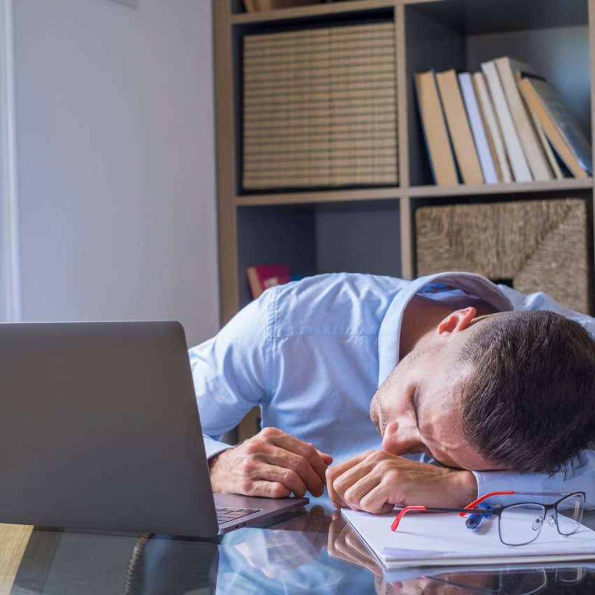 unmotivated man half asleep at his desk after saying he's too tired