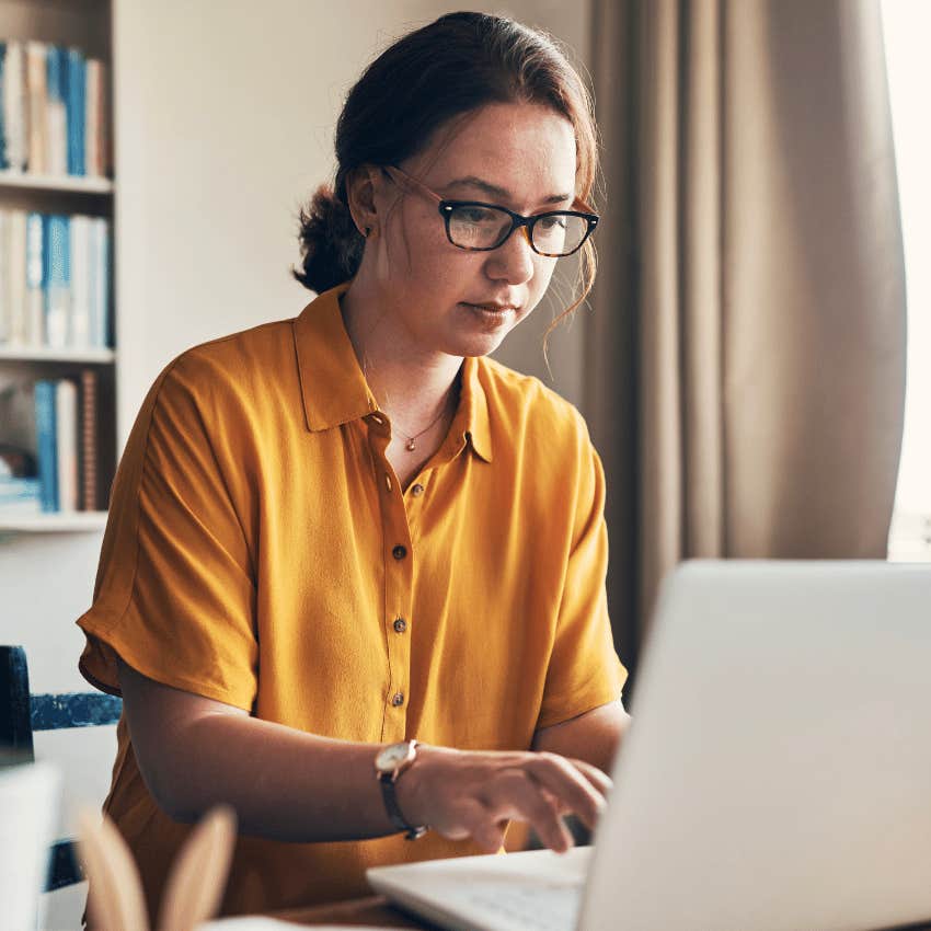 serious woman typing on laptop