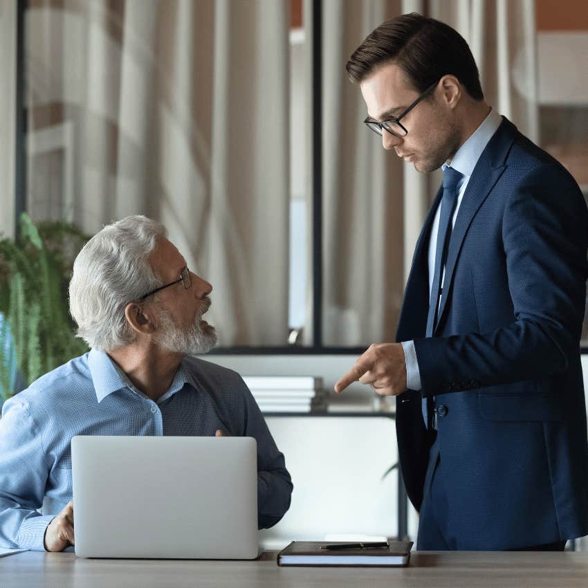shocked older employee looking up at his employer
