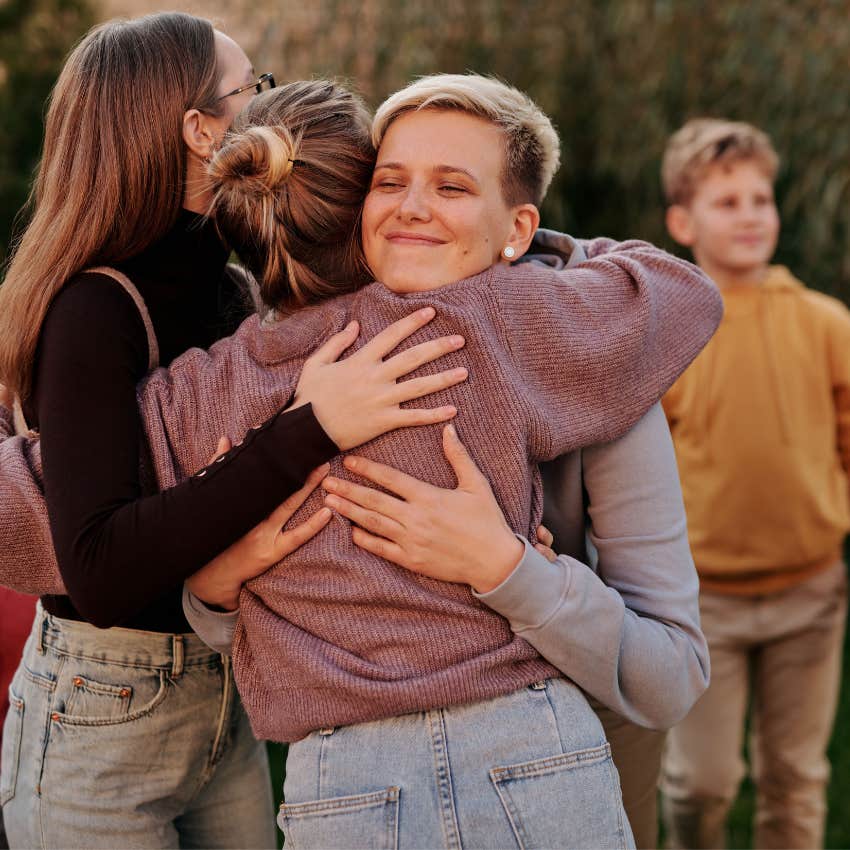 Adult siblings hugging after having a supportive conversation while spending time together