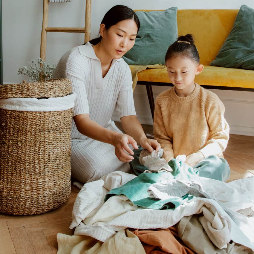mom helping daughter fold clothes instead of teaching her how to do it herself