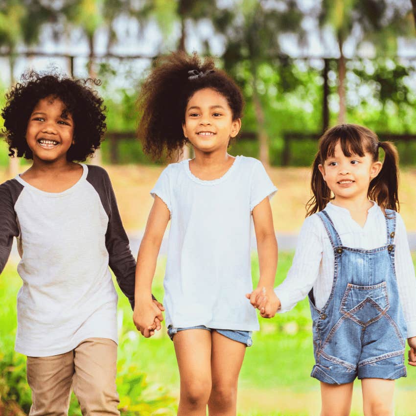 smiling kids holding hands walking together