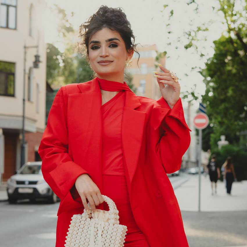 rich confident woman wearing red standing outside