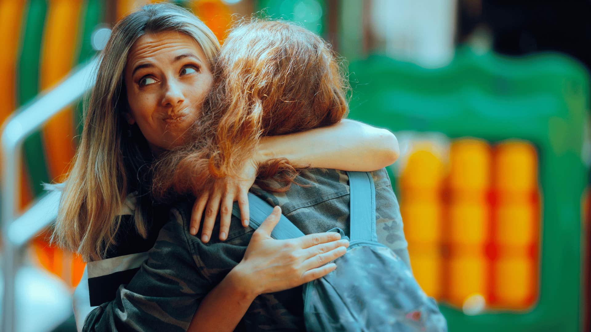 narcissistic woman hugging friend annoyed she's not getting attention