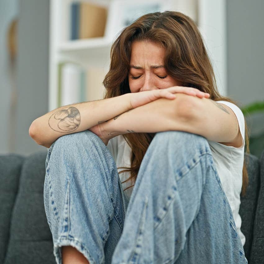 woman crying on couch who was emotionally neglected as a kid
