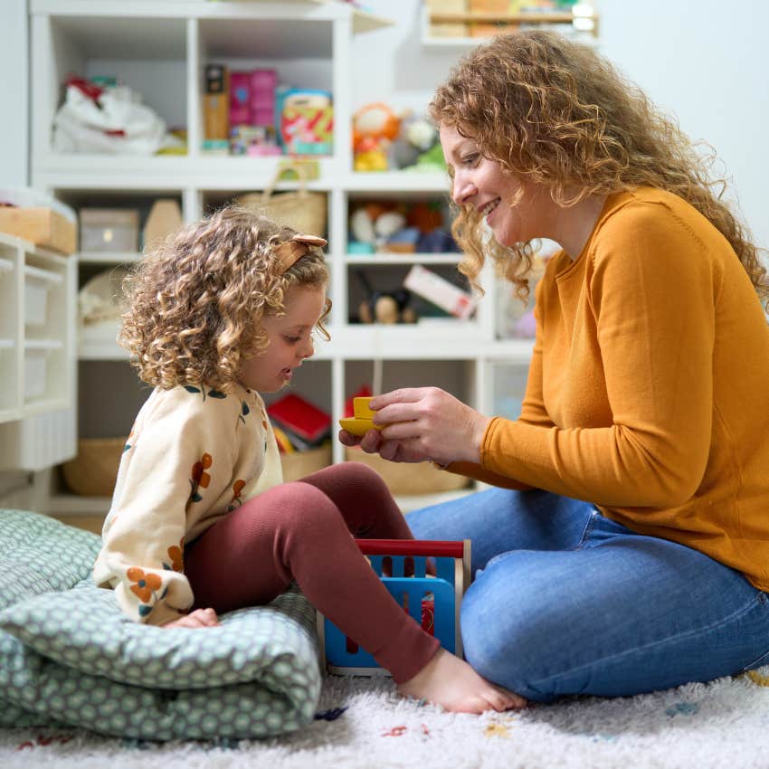 mom playing with daughter on floor telling her she is capable