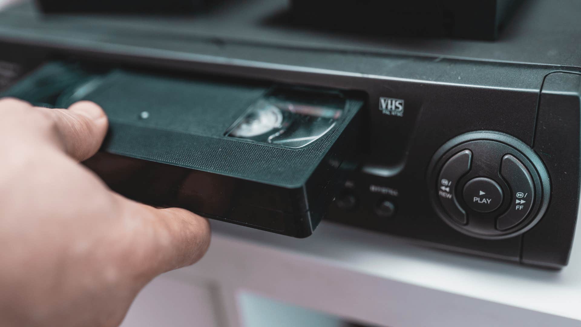 man rewinding vhs tapes before returning them