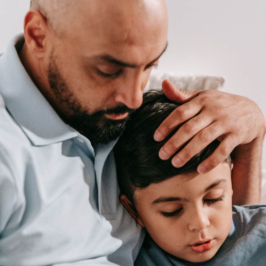 dad comforting his upset son lovingly