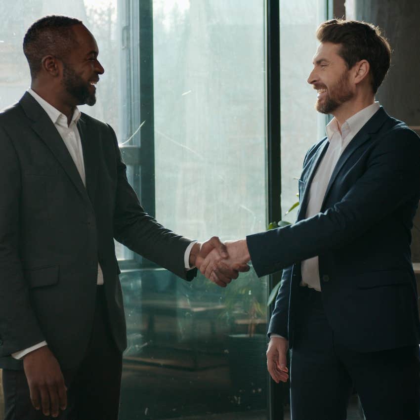 two old-school co-workers showing each other respect with a handshake