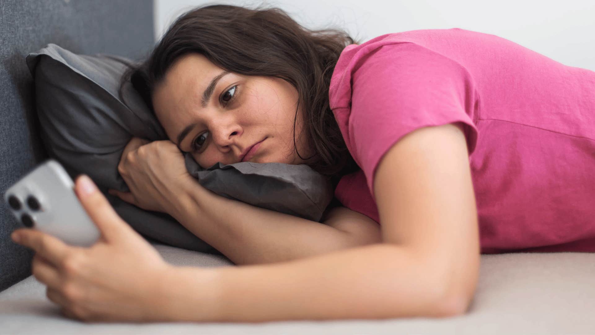 stressed woman answering emails from bed