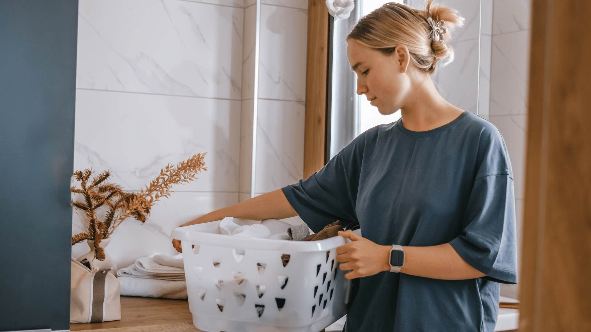 woman taking a break working from home to fold laundry