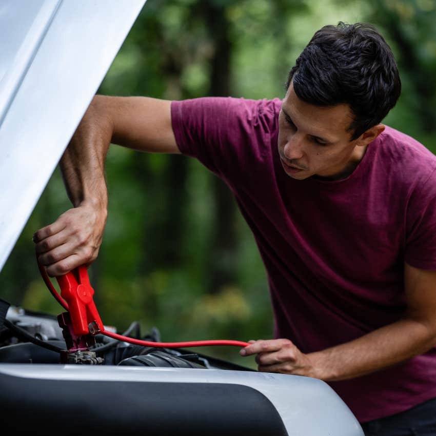man who never panics during an emergency using jumper cables to charge his car battery
