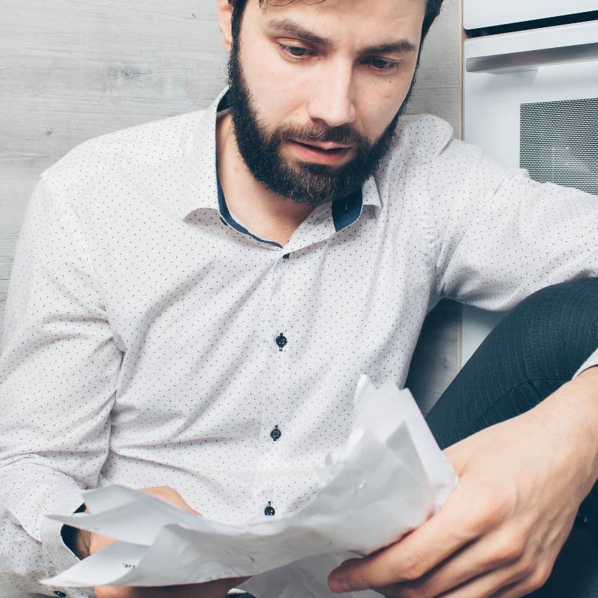 middle aged man looking at his collection of paper receipts