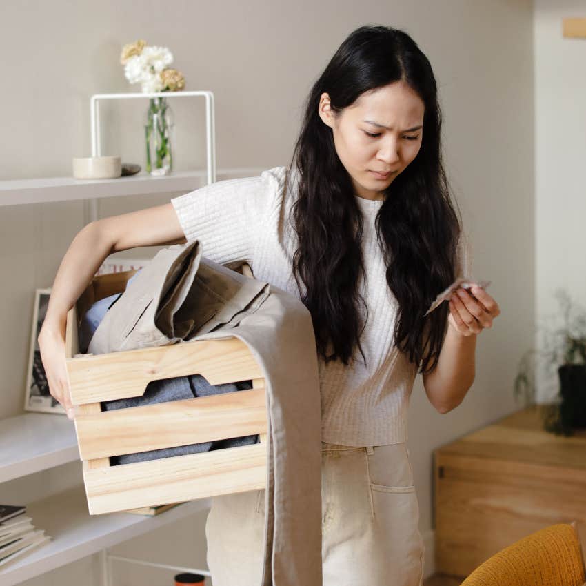 woman going through a box of unfixable broken items