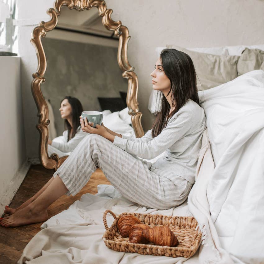 woman sitting in her bedroom in front of mirror