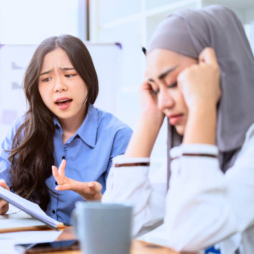Woman complaining around her stressed co-worker.