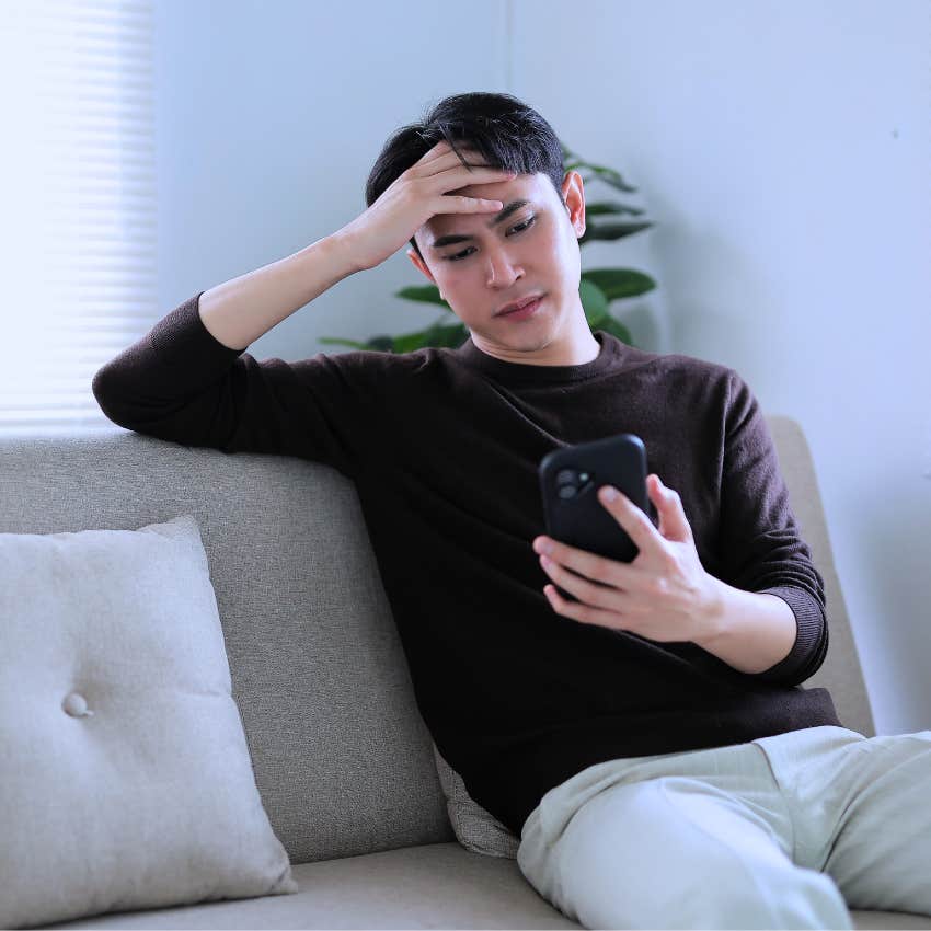 sad and lonely man looking at his phone not answering calls or texts