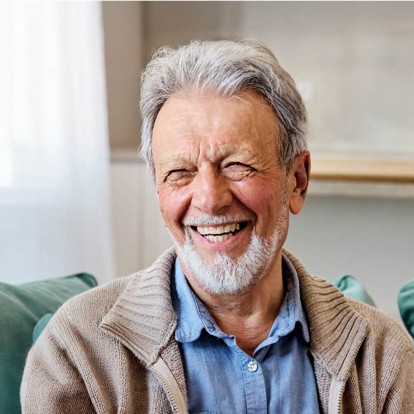 happy older man smiling who has stopped paying attention to his past life mistakes