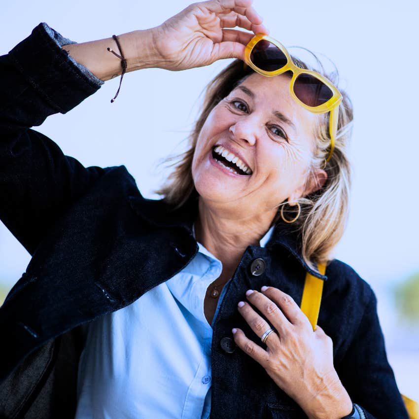 Woman who's not making herself smaller to please other people smiling outside.