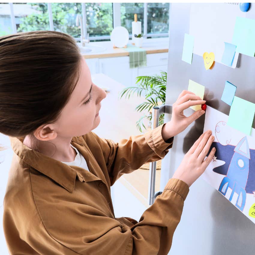 woman committed to an aesthetic putting things on the fridge