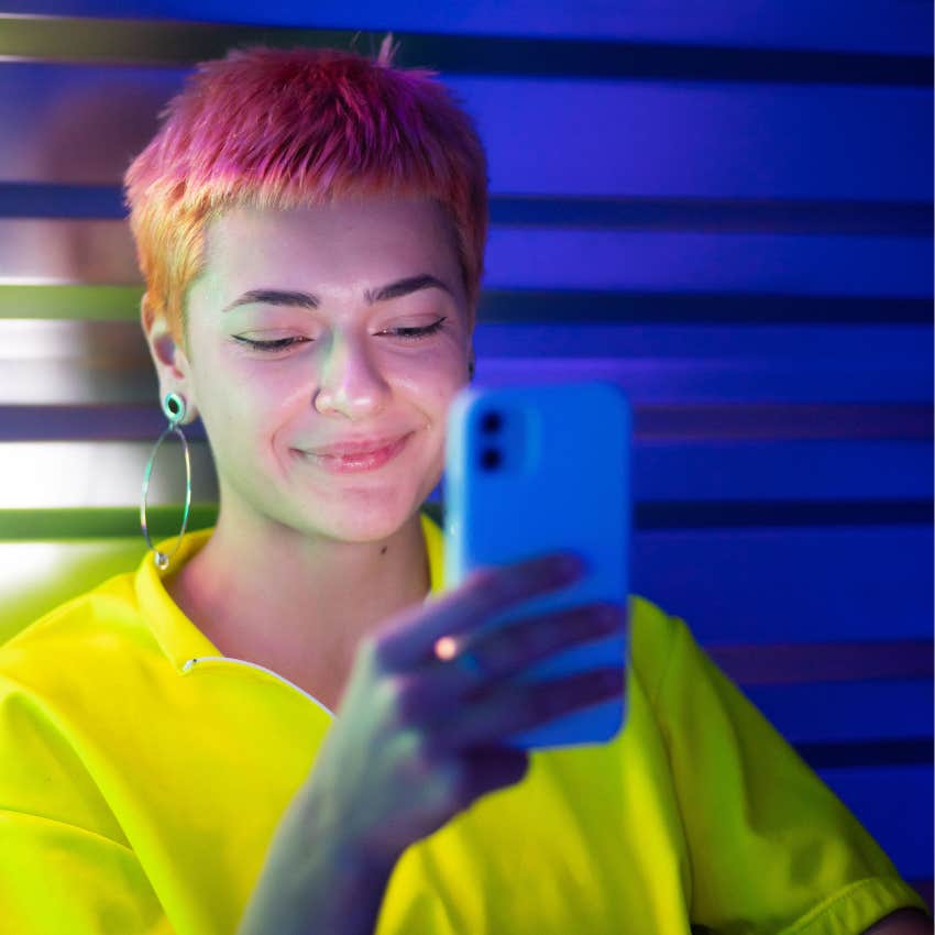 young person using their phone smiling 