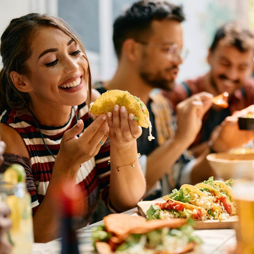 woman who spends money on food dining out on tacos with friends