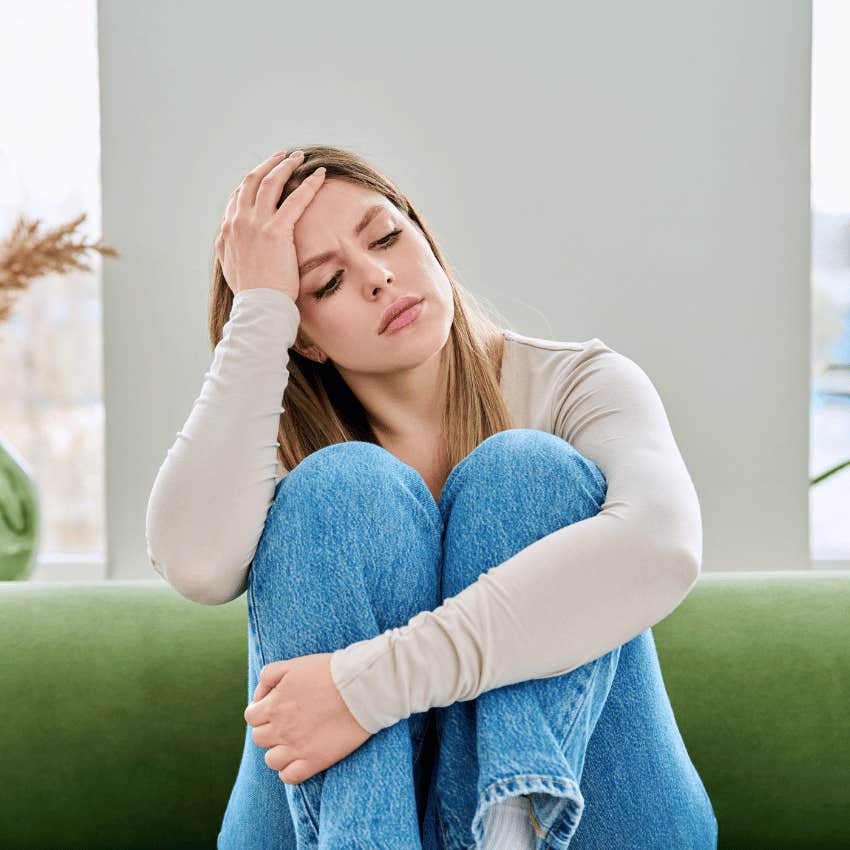 unhappy upset woman sitting alone on a couch