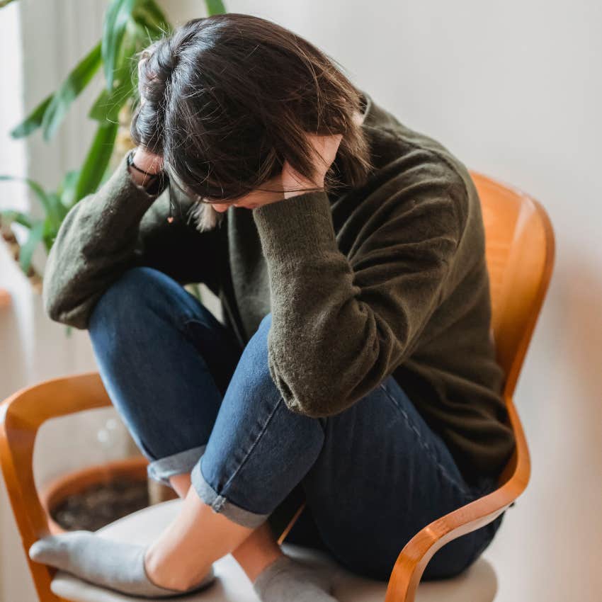overwhelmed woman sitting in a chair upset