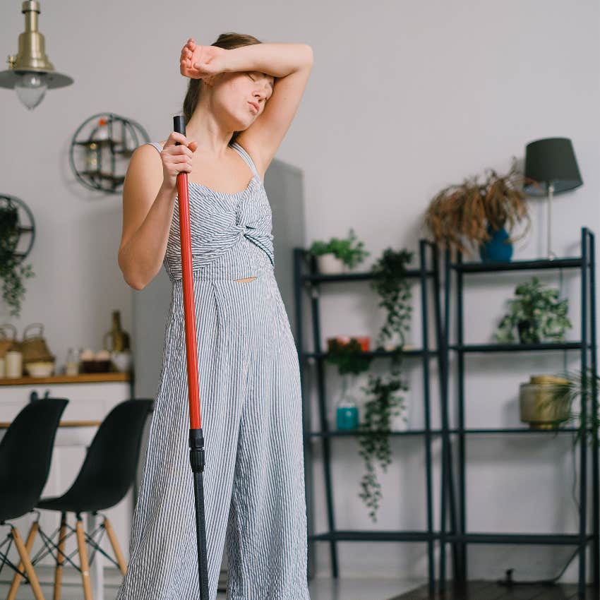 woman with too much stress and not enough affection looking sad with a broom